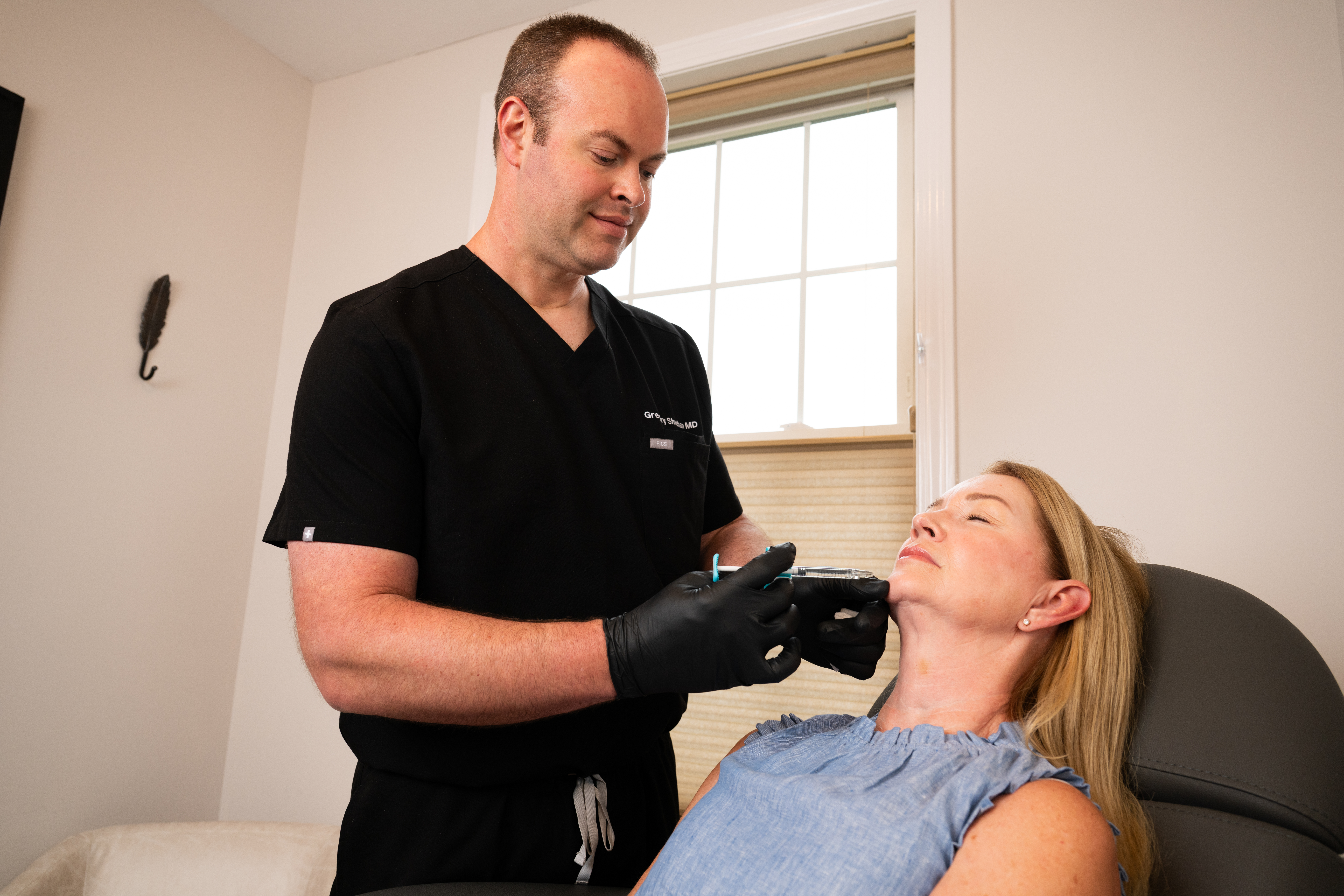 Dr. Greg Sheehan administering inectable treatment to a female patient